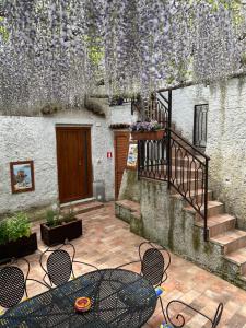 un patio esterno con tavolo, sedie e fiori di Il Limoneto di Teresa Amalfi Coast a Maiori