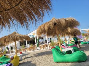 a group of people sitting on the beach under umbrellas at REYNA APART HOTEL in Constanţa