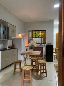 a kitchen with a table and some stools in it at Apartamento Estrada Real - Apart Hotel em Marmelópolis in Marmelopolis