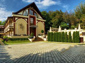 een huis met een stenen oprit ervoor bij Hotel Vila Lago in Palić