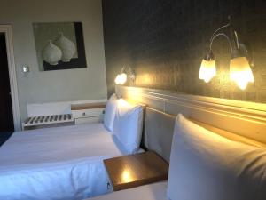 a hotel room with two beds and lights on the wall at The Continental Hotel, Derby in Derby