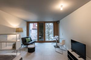 a living room with a television and a table and chairs at WEST Apartments in Schorndorf