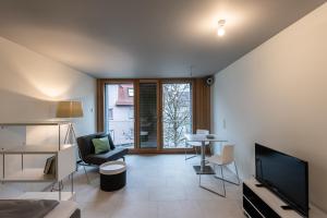 ein Wohnzimmer mit einem TV, einem Tisch und Stühlen in der Unterkunft WEST Apartments in Schorndorf