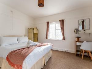 1 dormitorio con 2 camas, escritorio y ventana en Pass the Keys 3 bedroom bungalow perfectly located parking en Poole