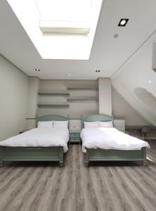 two beds in a room with a skylight at Castle On A Cloud in Renai