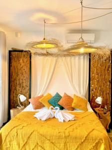 a bedroom with a bed with yellow sheets and pillows at La Villa Tosca in Callas