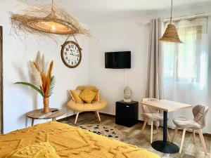 a bedroom with a clock and a table and chairs at La Villa Tosca in Callas