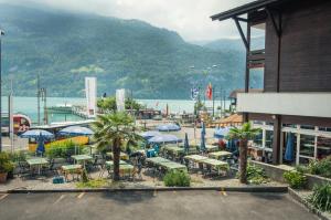 eine Gruppe von Tischen und Sonnenschirmen in einer Stadt in der Unterkunft Hotel Weisses Kreuz in Brienz