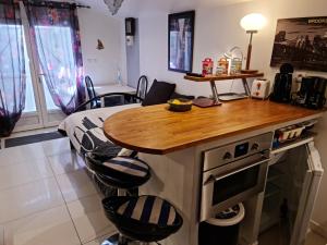 a kitchen with a island with a table and chairs at REDHOUSE Studios Roques - Zen in Roques Sur Garonne