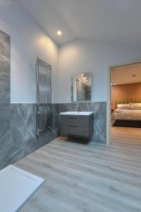 baño con lavabo, espejo y cama en Little John Hotel, en Hathersage