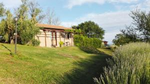 una casa su una collina erbosa con un edificio di Il Poggio Dell'Artilla a Castiglione in Teverina