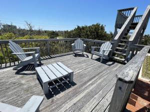 two chairs and a bench on a wooden deck at 57310 Eagle Pass Rd Home in Hatteras