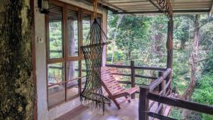 a hammock on the porch of a tree house at Whitetea Estatehouse Tree House in Munnar +17 photos