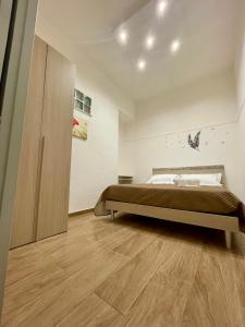 a bedroom with a bed and a wooden floor at Kiberosa in Isola delle Femmine