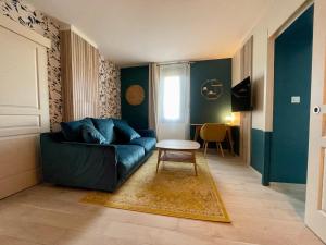 ein Wohnzimmer mit einem blauen Sofa und einem Tisch in der Unterkunft Bastide Beaudinard in Aubagne