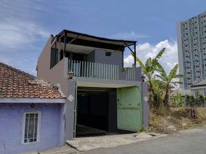 un edificio púrpura con una puerta verde y un balcón en OYO Life 91116 Pelangi Residence Syariah, en Jatiroke