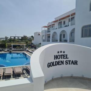 a hotel room with a pool table and chairs at Golden Star in Fira