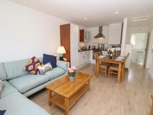 a living room with a couch and a table at 8 Munday Cottages in Yarmouth