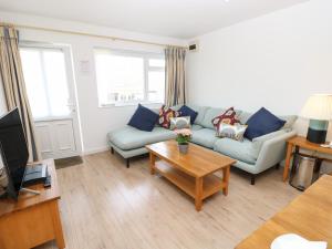 a living room with a couch and a table at 8 Munday Cottages in Yarmouth