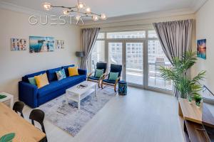 uma sala de estar com um sofá azul e uma mesa em Shoreline The Palm, Free beach & pool access em Dubai