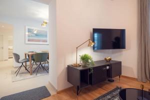 uma sala de estar com televisão e uma mesa com cadeiras em Ideal for Families & Mid-Term-Stays em Viena