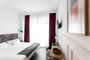 um quarto de hotel com uma cama e uma mesa em Hotel Trueba em San Sebastián