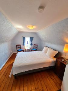 プレーンにあるExklusive Ferienwohnung Strohbergのベッドルーム1室(ベッド1台、椅子2脚、窓付)