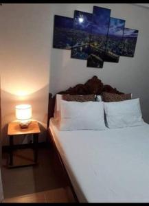 a bedroom with a bed and a table with a lamp at Cubao ManhattanHeights Unit 23D Tower C, 1 BR in Manila