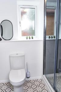 a bathroom with a toilet and a window and a mirror at Parkway House - Modern with great transport links in Bristol