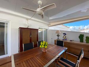 une salle à manger avec une table en bois et un ventilateur de plafond dans l'établissement Ático en Javea pueblo “Patraix”, à Jávea