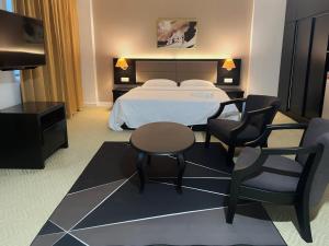 a hotel room with a bed and a table and chairs at Remington Hotel in Muar