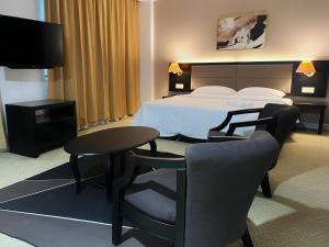 een hotelkamer met een bed en een tafel en stoelen bij Remington Hotel in Muar