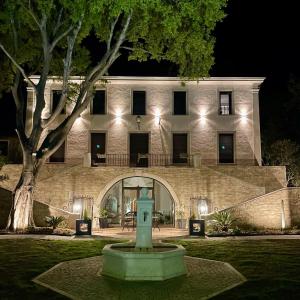 ein Gebäude mit einem Brunnen in der Nacht davor in der Unterkunft Bastide Beaudinard in Aubagne