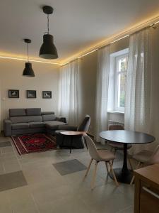 een woonkamer met een bank en een tafel en stoelen bij Apartament Bankowy in Olecko