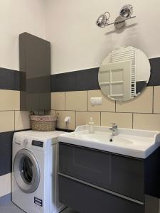 a bathroom with a washing machine and a sink at Apartament Bankowy in Olecko