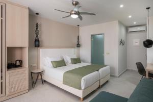 a bedroom with a bed and a ceiling fan at Sirios Village Hotel & Bungalows - All Inclusive in Kato Daratso