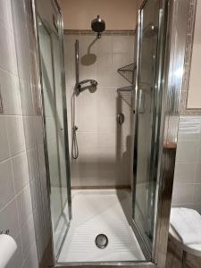 una doccia con porta in vetro in bagno di Viole Country Hotel ad Assisi