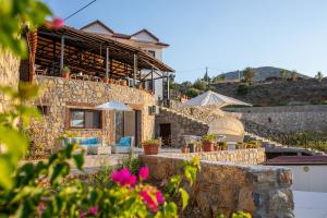 a house on the side of a hill with flowers at Selimiye Lime Garden in Selimiye