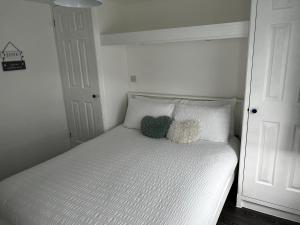 una cama blanca con dos animales de peluche sentados en ella en Surfs Up Lodge - Westward Ho!, en Westward Ho