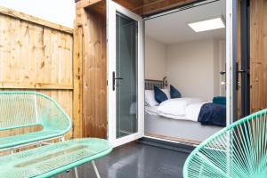 シュルーズベリーにあるThe Garden Houseのベッド1台、椅子2脚、窓が備わる客室です。