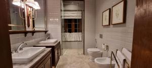 a bathroom with two sinks and a toilet and a shower at Kandy Dendrobium House in Kandy