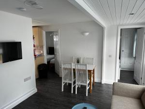 ein Wohnzimmer mit einem Tisch, Stühlen und einem Sofa in der Unterkunft Surfs Up Lodge - Westward Ho! in Westward Ho