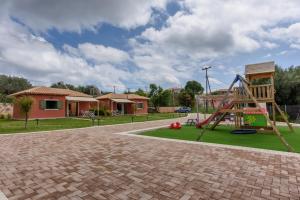 a playground with a slide in a yard at Comfeto & Mandolato Sweet Houses in Lakíthra