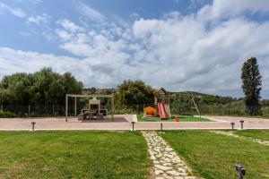 einen Park mit Spielplatz mit Schaukel in der Unterkunft Comfeto & Mandolato Sweet Houses in Lakíthra
