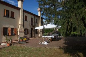 un patio con mesa y sombrilla frente a un edificio en B&B FETONTE en Crespino