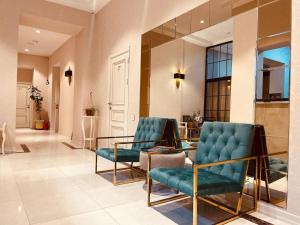 a lobby with two blue chairs and a glass table at Seven Boutique Hotel Baku in Baku