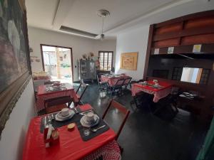 uma sala de jantar com mesas vermelhas e cadeiras num quarto em POUSADA BEIRUTE em Cabo Frio