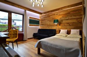 シュクラルスカ・ポレンバにあるWilla Lenaのベッドルーム1室(ベッド1台、椅子、ソファ付)