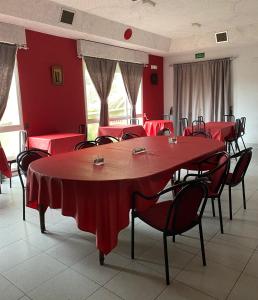Habitación con mesas y sillas rojas y paredes rojas. en A lastra, en Villamartín