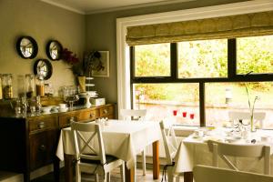 uma sala de jantar com mesas e cadeiras e uma janela em Ben Breen House B&B em Clifden